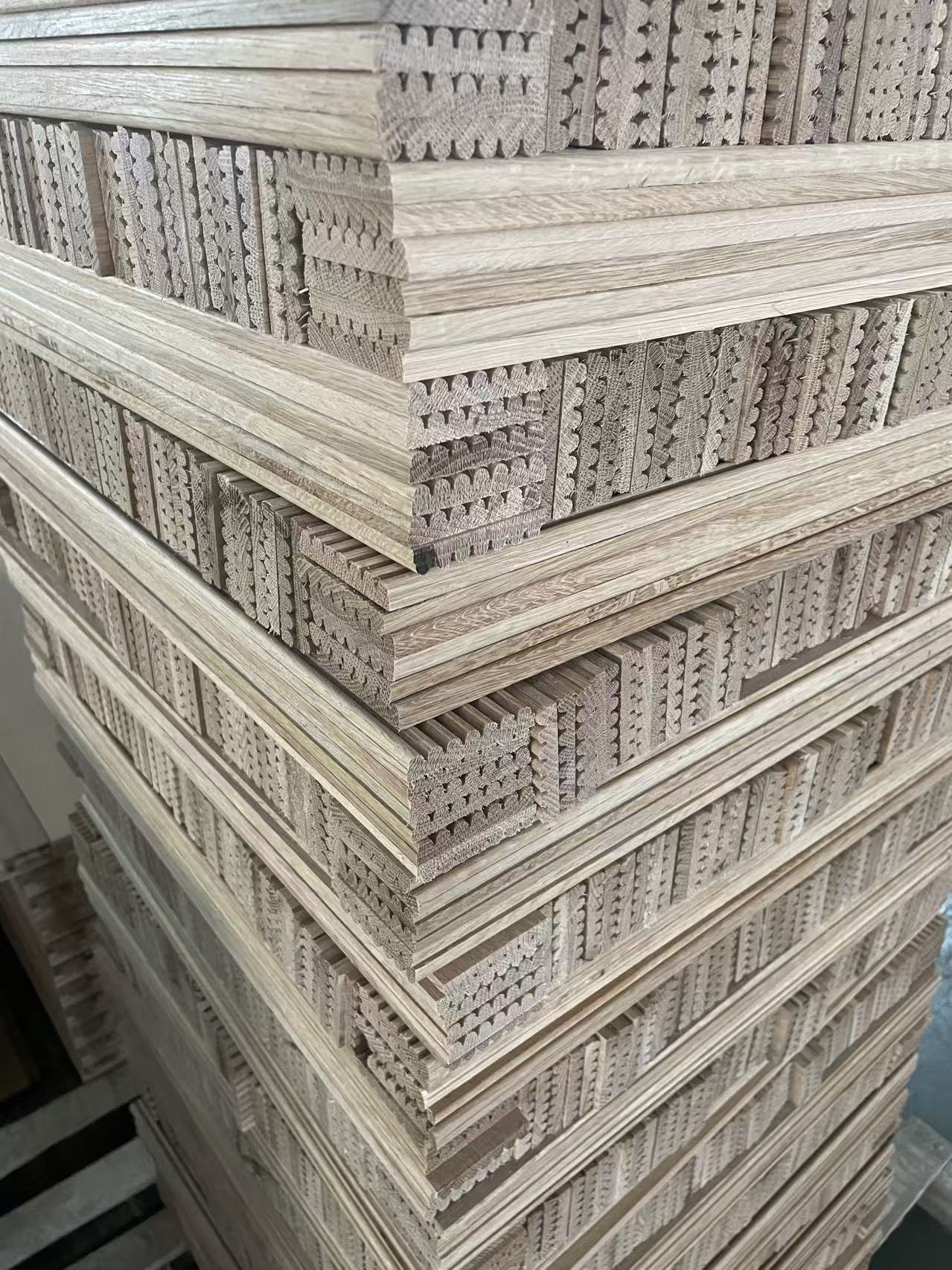 Stacked carved oak panel components in workshop